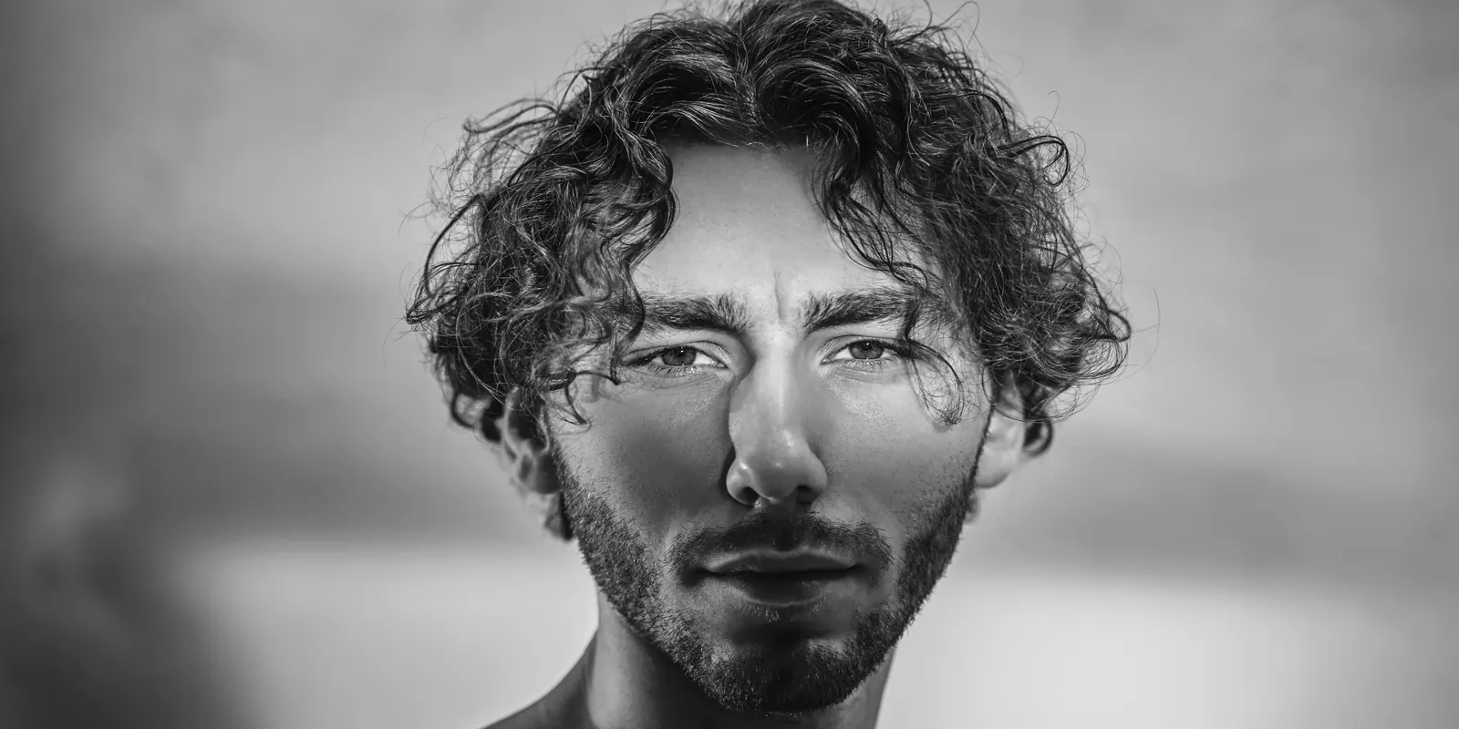 Sample plate — a wide editorial portrait against soft atmosphere, treated monochrome